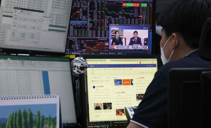 A　trader　at　KEB　Hana　Bank's　dealing　room　in　Seoul　watches　financial　market　data　and　news