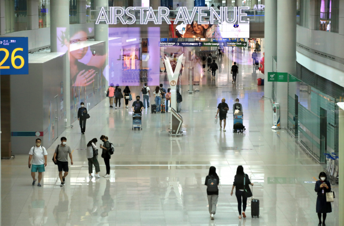 Travelers in the duty-free section of the Incheon International Airport on June 26