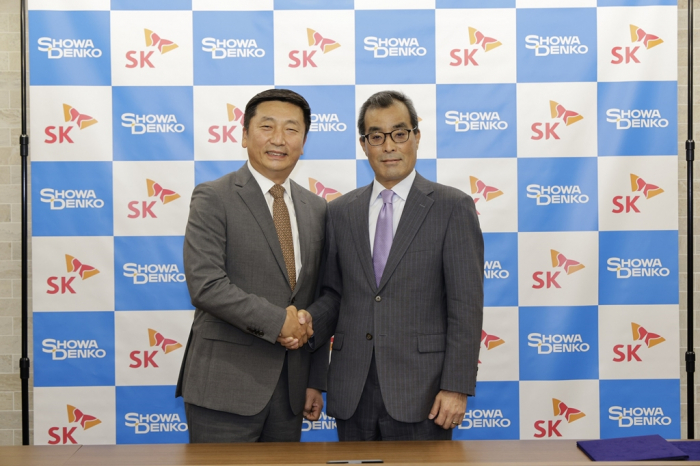 SK Materials CEO Lee Young-wook (left) and a Showa Denko executive sign a chip materials cooperation MOU
