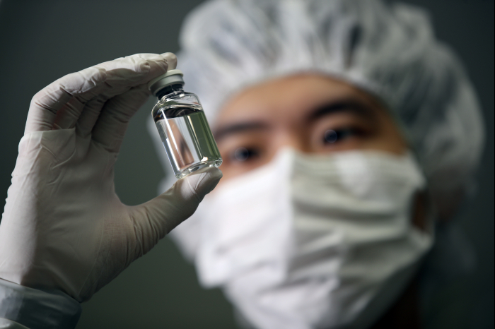 A　researcher　holds　up　a　vial　of　Regkirona　developed　by　Celltrion