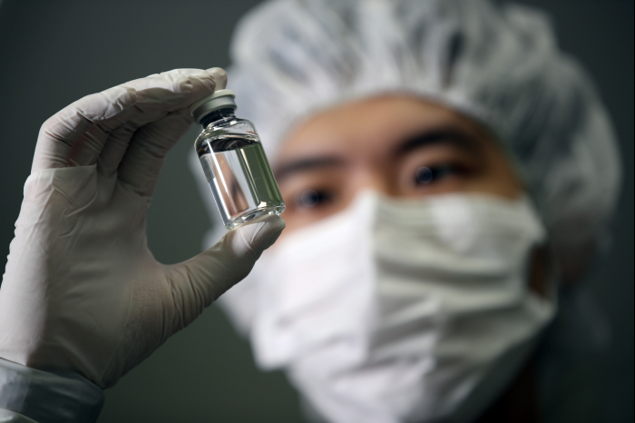 A researcher holds up a vial of Regkirona developed by Celltrion