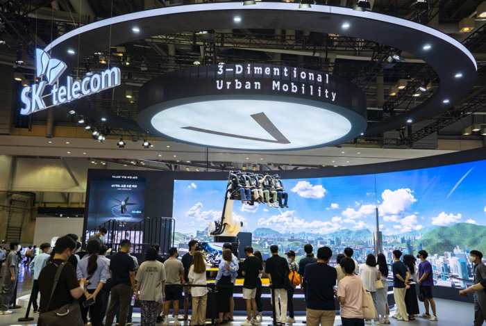 Visitors　to　the　2022　Busan　International　Motor　Show　experience　the　UAM　simulator　at　SK　Telecom’s　booth　(Courtesy　of　SK　Telecom)