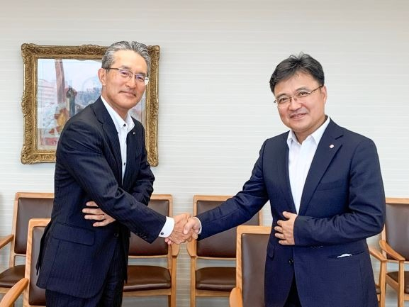 Masaya Tanaka, Itochu’s president of energy & chemical unit (left) and Hwang Jin koo, Lotte’s president of basic material business, shake hands after signing a memorandum of understanding on cooperation on July 21, 2022, at Itochu headquarters in Tokyo (Courtesy of Lotte Chemical)