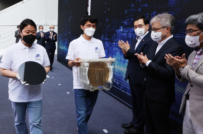Samsung　Electronics　researchers　carry　3　nm　wafers　at　a　July　25,　2022　ceremony　in　Hwaseong,　Gyeonggi　Province,　to　mark　the　world's　first　shipment　of　the　advanced　chips. 