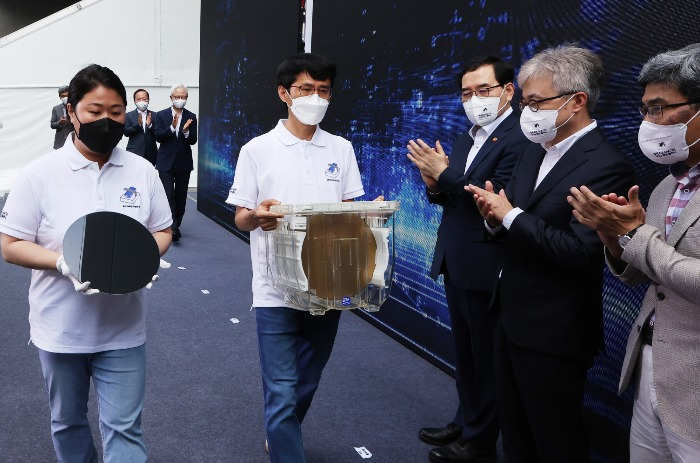Samsung Electronics researchers carry 3 nm wafers at a July 25, 2022 ceremony in Hwaseong, Gyeonggi Province, to mark the world's first shipment of the advanced chips.