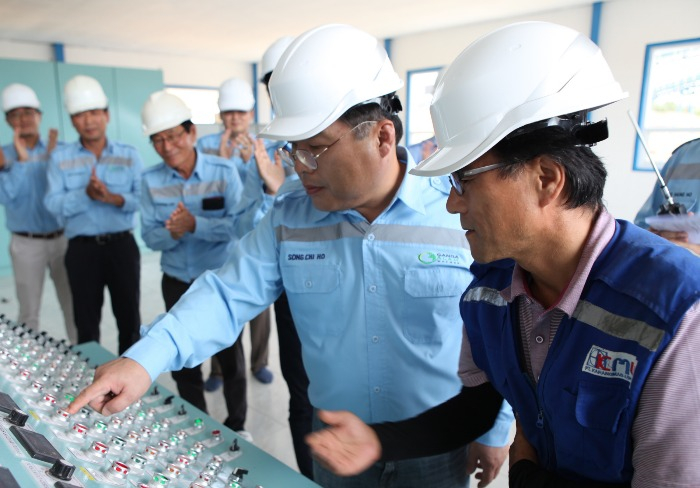 Song　Chi-ho,　then-CEO　of　LG　International　(second　from　the　right),　checking　on　the　control　panel　for　the　GAM　coal　mine　in　Indonesia　in　2017　(Courtesy　of　LX　International)
