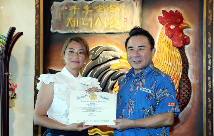 Ellen Park, an assemblywoman in the New Jersey Legislature (left), presents Yoon Hong-guen, chairman of Genesis BBQ, the South Korean operator of BB.Q, with a plaque of thanks on Aug. 12, 2022