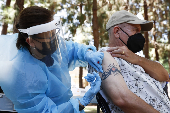 A　medical　doctor　administers　a　vaccine　shot　to　a　man