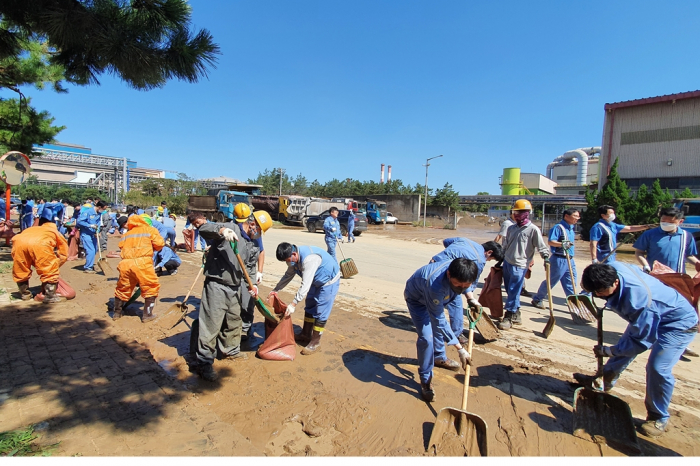 POSCO　employees　remove　mud　at　its　Pohang　plant