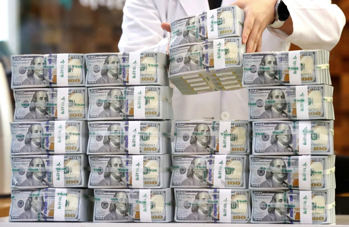 A　Hana　Bank　official　piles　bundles　of　dollars　at　its　headquarters　on　Sept.　14,　2022　(Courtesy　of　News1)