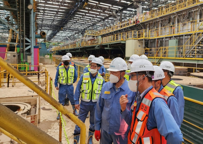 POSCO　officials　including　Group　Chief　Executive　Choi　Jeong-woo　(without　a　safety　vest)　inspect　an　electric　steel　sheet　plant　at　Pohang　Steel　Mill,　which　is　under　drainage　and　mud　removal　works,　on　Sept.　12,　2022　(Courtesy　of　POSCO)