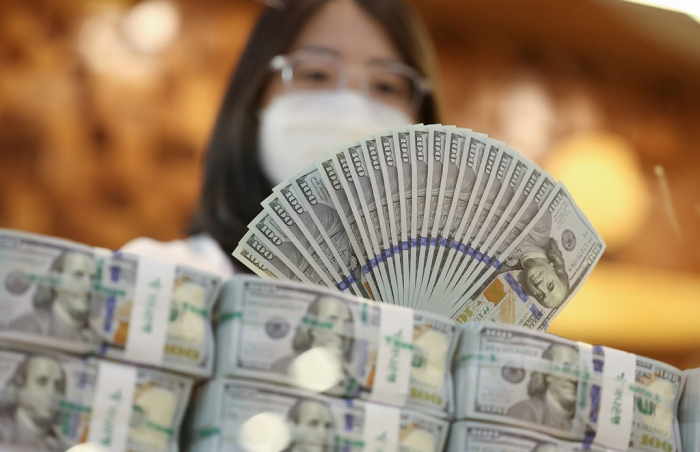 A　Hana　Bank　employee　displays　0　notes　at　the　bank's　headquarters　in　central　Seoul　(Courtesy　of　Yonhap)