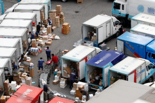 Workers　move　products　at　a　logistics　center　in　Seoul　(Courtesy　of　News1)