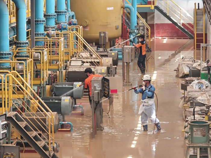 POSCO employees remove mud at its Pohang plant flooded by Typhoon Hinnamnor