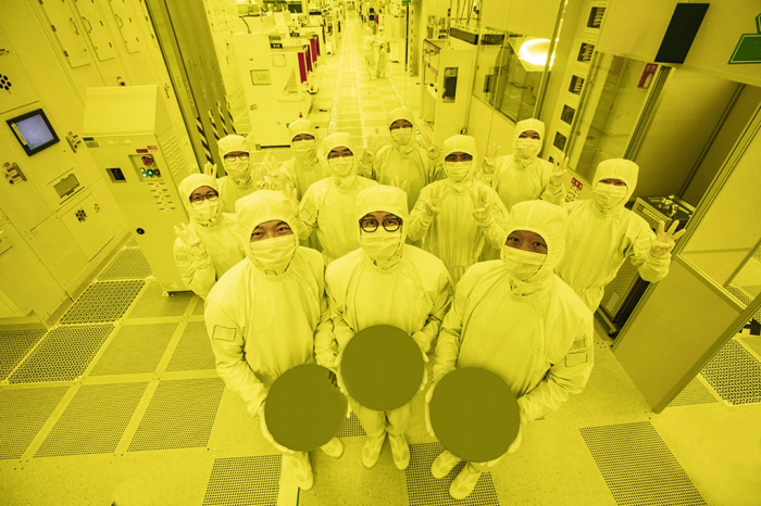 Samsung　employees　hold　chip　wafers　produced　with　its　3-nanometer　processing　tech