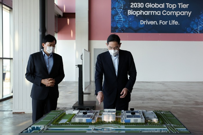 Samsung　Group　de　facto　leader　Jay　Y.　Lee　points　to　a　diorama　of　Samsung　Biologics'　newly　built　fourth　CDMO　factory　in　Songdo,　Incheon,　on　Oct.　11,　2022　(Courtesy　of　Samsung)