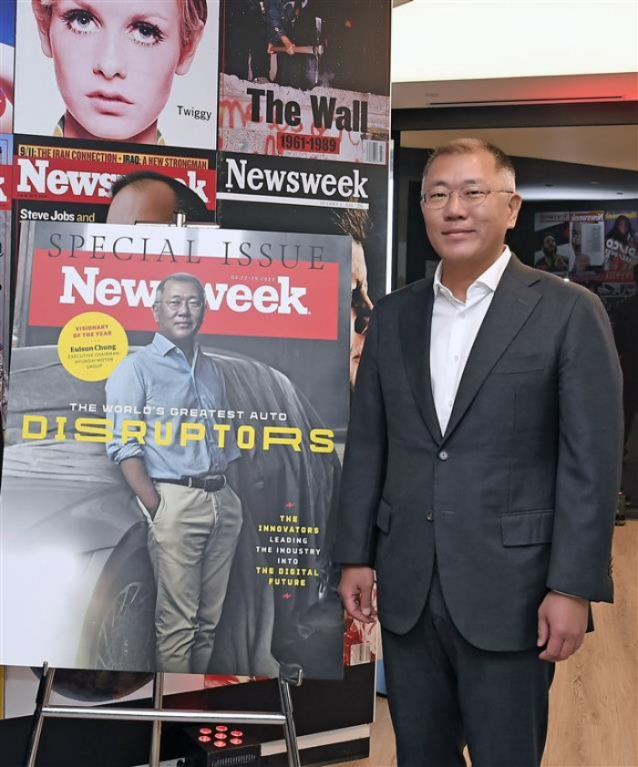 Hyundai Motor Chairman Chung Euisun poses next to a publicity poster for Newsweek's April-22-29 cover