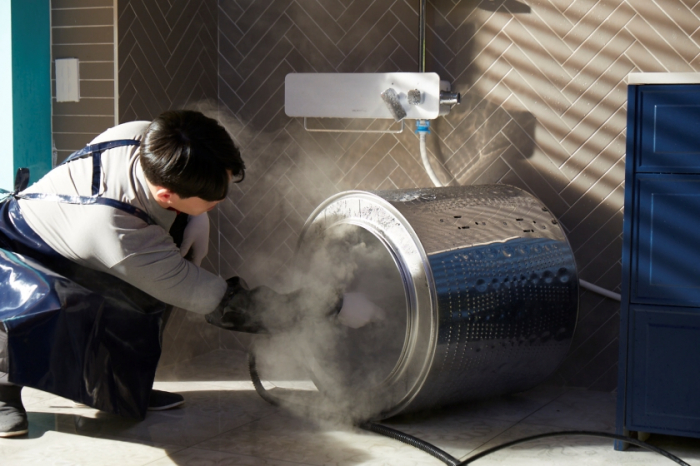 An LG Electronics technician cleans a washing machine (Courtesy of LG Electronics)