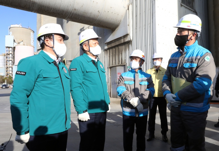 Trade and Industry Minister Won Hee-ryong (left) visits a cement company as truckers continue their strike