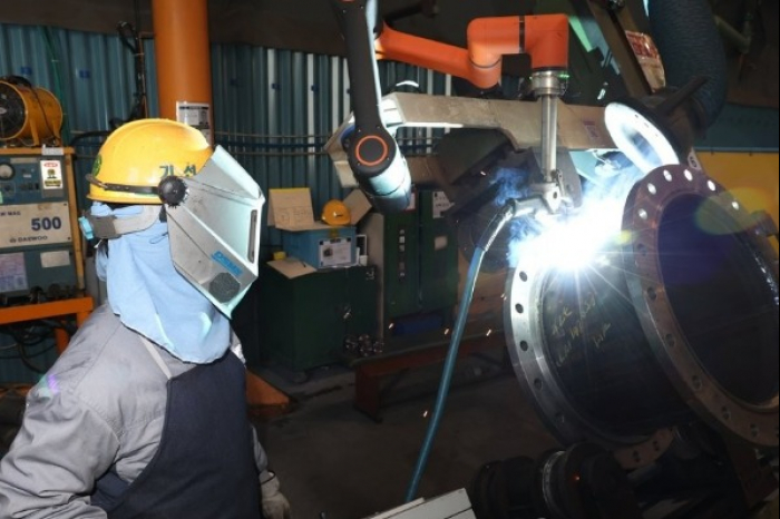 A worker of DSME with a collaborative robot (Courtesy of Yonhap)