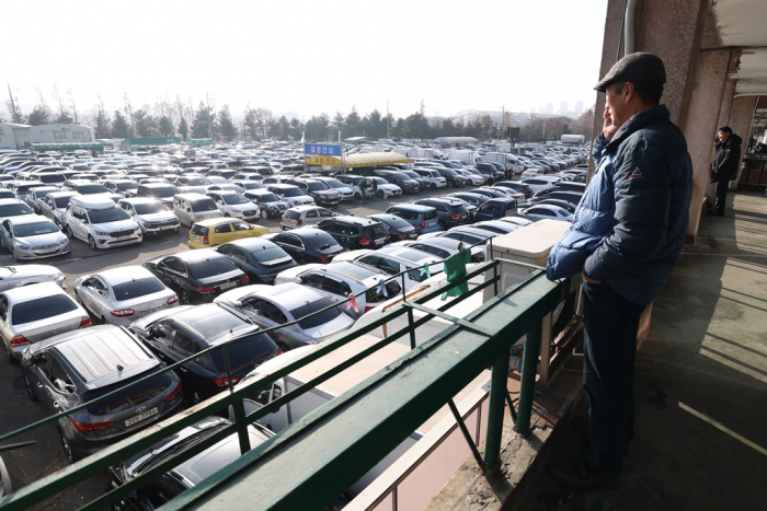 A　man　looks　at　used　cars　in　Janganpyeong,　Korea's　largest　secondhand　car　market