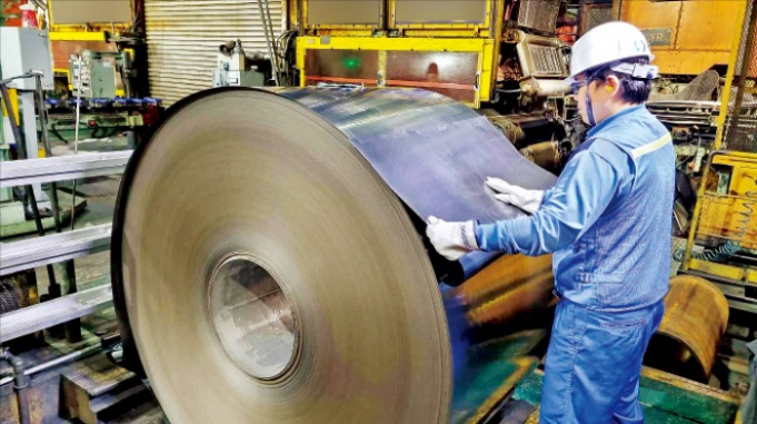 A　POSCO　factory　worker　inspects　a　steel　sheet　roll