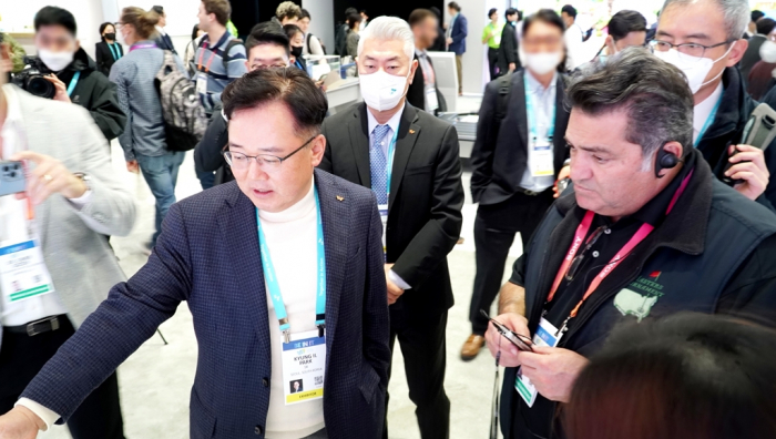 SK　Ecoplant　CEO　Park　(left)　and　Plug　and　Play　CEO　Saeed　Amidi　look　around　at　the　SK　booth　at　CES　2023