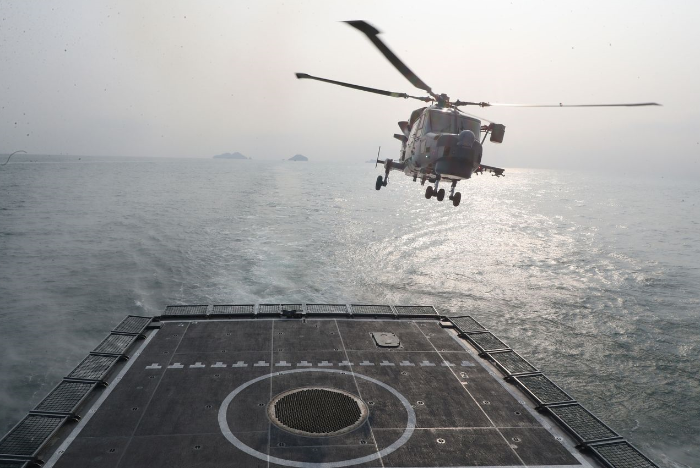 A　helicopter　takes　off　from　the　South　Korean　Navy’s　destroyer　during　live-fire　drills　in　waters　off　Taean,　South　Korea