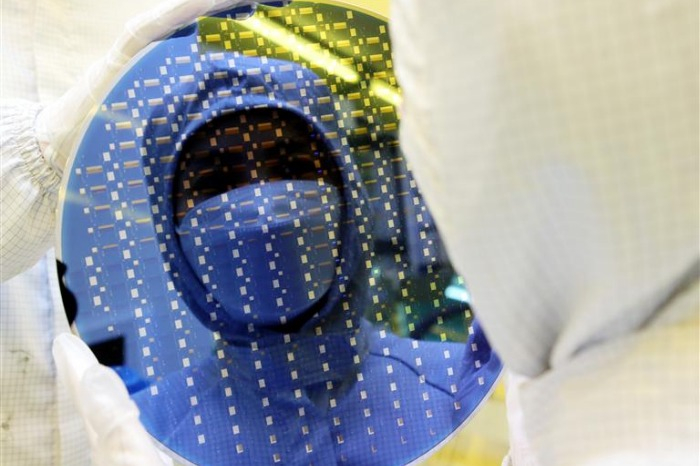 A Samsung employee examines a wafer