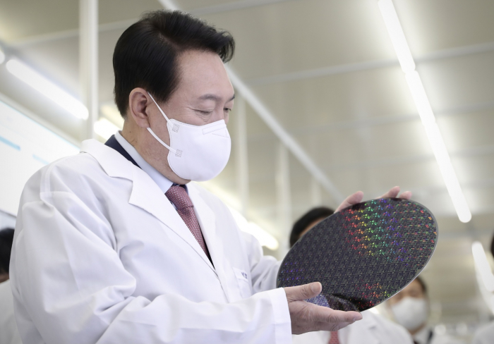 President　Yoon　Suk-yeol　looks　at　a　chip　wafer　during　his　visit　to　KAIST