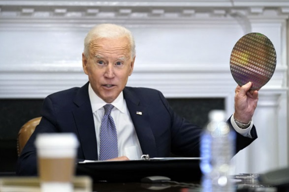 Joe　Biden　holds　up　a　silicon　wafer　during　a　virtual　meeting　with　CEOs　to　discuss　supply　chain　issues　at　the　White　House　in　April　2021.