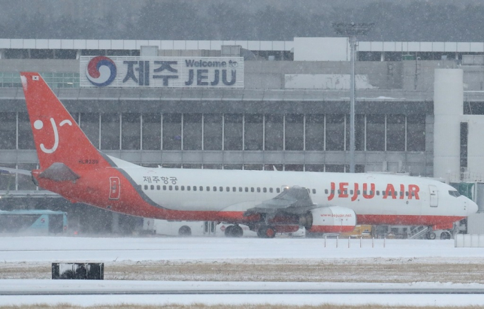 A　Jeju　Air　aircraft　grounded　on　the　icy　runway　of　Jeju　International　Airport　due　to　heavy　snow.　S.Korea’s　environment　ministry　said　on　March　6,　2023　it　conditionally　approves　the　construction　of　a　new　airport　on　Jeju　as　the　land　ministry　pushes　for　the　new　facility　given　the　existing　airport's　frequently　canceled　flights　(Courtesy　of　Yonhap)