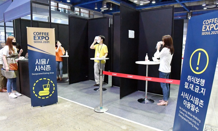 Visitors　sample　coffee　under　social　distancing　measures　at　Coffee　Expo　Seoul　2021　when　South　Korea　imposed　strict　rules　against　COVID-19
