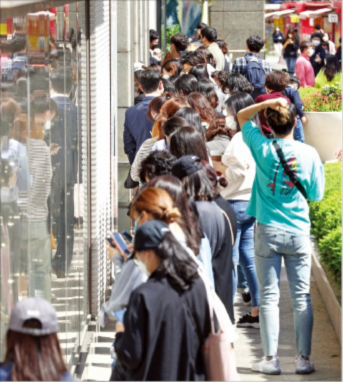 Shoppers　wait　in　a　long　line　outside　a　Chanel　store　a　day　before　it　sharply　hiked　its　handbag　prices　in　2020