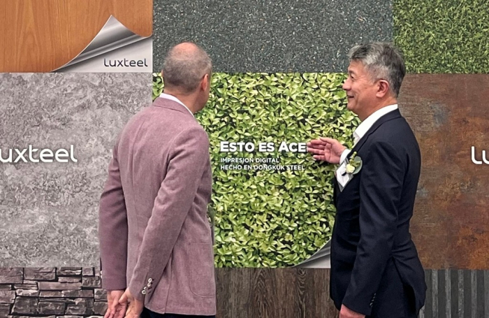 Dongkuk　Steel　Vice　Chairman　Chang　Sae　Wook　(right)　explains　its　premium　product　Luxteel　to　a　customer　who　attends　the　completion　ceremony　of　its　second　Mexican　color-coated　plant　(Courtesy　of　Dongkuk)