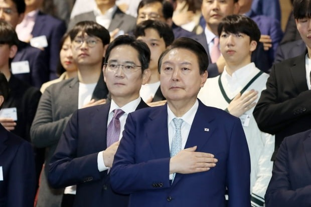 Samsung　Electric　Chairman　Jay　Y.　Lee　(center　left)　and　South　Korean　President　Yoon　Suk　Yeol　(next　to　Lee)　salute　the　South　Korean　flag　(Courtesy　of　Yonhap)