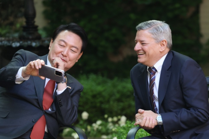 President Yoon shows Netflix Co-CEO Sarandos a video of his first pitch at an April 1 baseball game (Courtesy of Yonhap News)