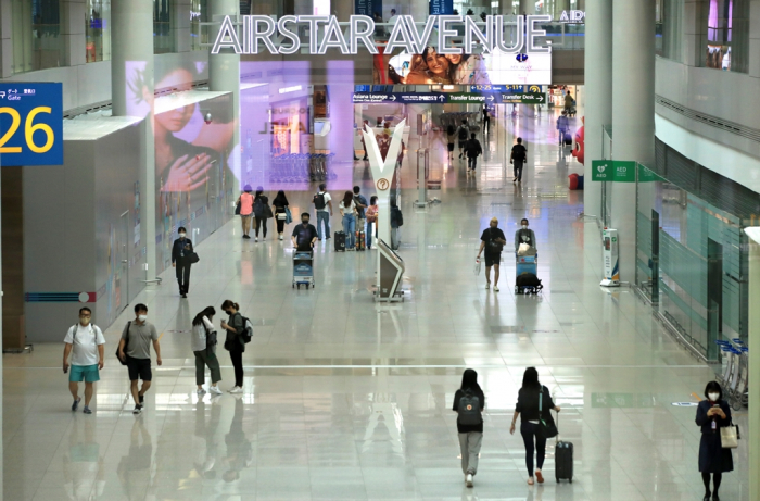 Travelers in the duty-free section of Incheon International Airport