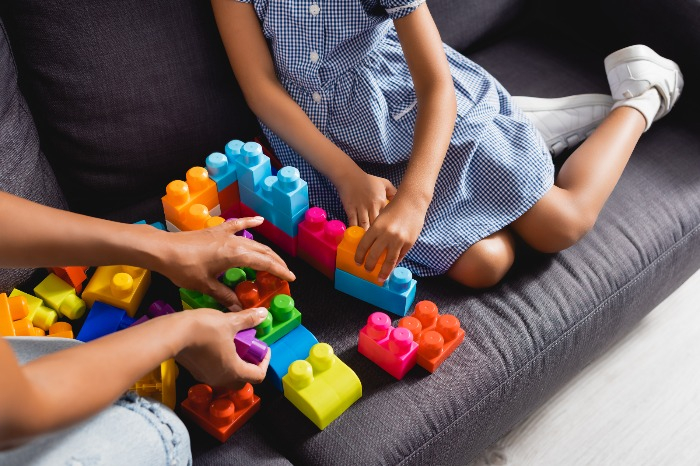 A　nanny　and　a　child　play　with　building　blocks　(Courtesy　of　Getty　Images)