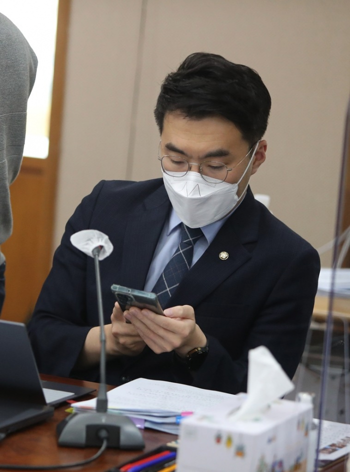 South　Korean　lawmaker　Kim　Nam-kuk　looks　at　his　mobile　phone　on　Oct.　14,　2022,　during　a　judiciary　committee　meeting　(File　Photo,　courtesy　of　Yonhap)