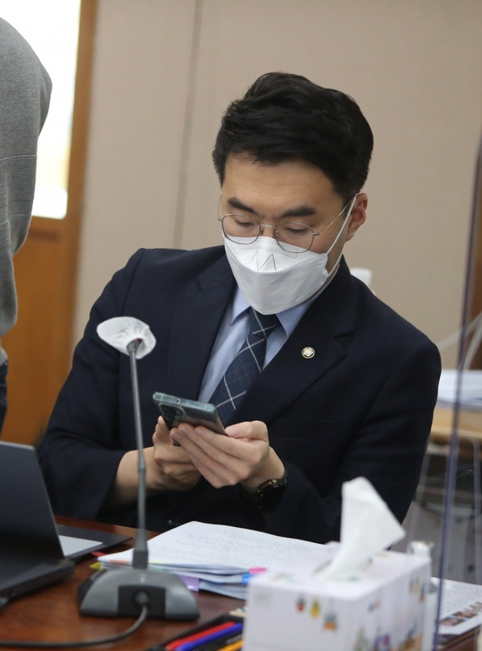 South Korean lawmaker Kim Nam-kuk looks at his mobile phone on Oct. 14, 2022, during a judiciary committee meeting (File Photo, courtesy of Yonhap)
