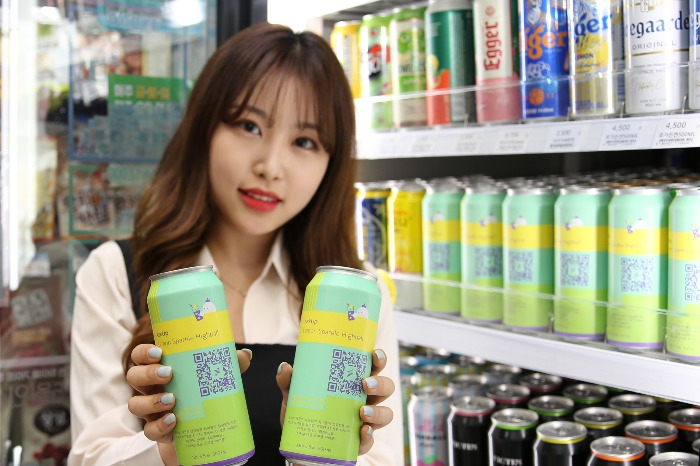 A model displays AskUp Lemon Sparkle Highball cans at a GS25 convenience store