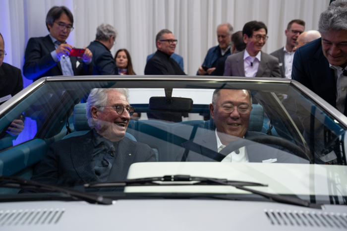 Hyundai　Motor　Chairman　Chung　Euisun　(right,　seated)　and　designer　Giogretto　Giugiaro　smile　in　the　Pony　Coupe　concept　restored　after　50　years　in　Italy　in　May　2023