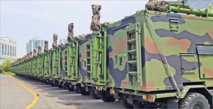 Camouflage trucks lined up outside of a Huneed factory in Incheon, South Korea