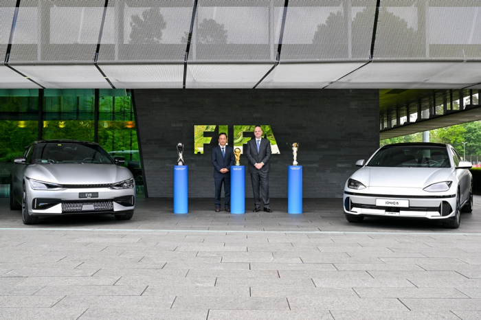 Hyundai　Motor　President　Karl　Kim　(left)　and　FIFA　President　Gianni　Infantino　flanked　by　Kia's　EV6　and　Hyundai's　IONIQ　6　electric　cars