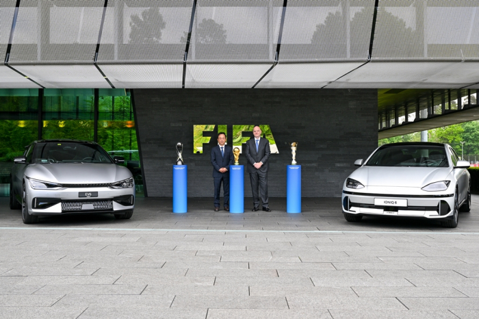 Hyundai Motor President Karl Kim (left) and FIFA President Gianni Infantino flanked by Kia's EV6 and Hyundai's IONIQ 6 electric cars