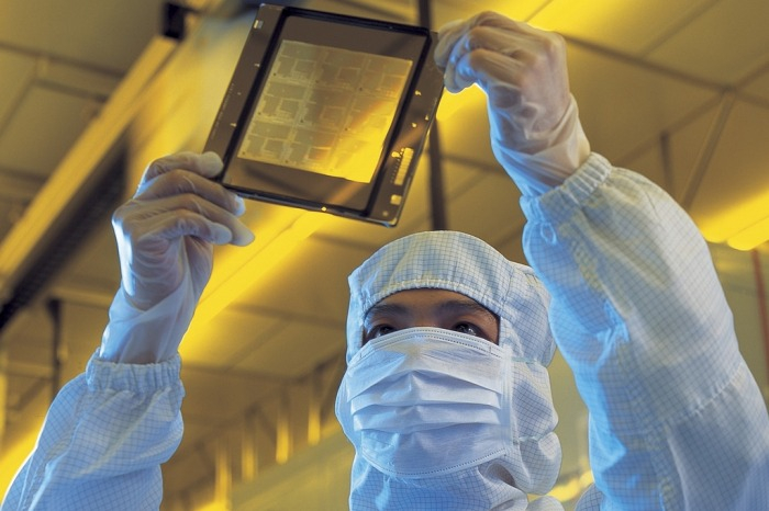 An employee at a Korean chipmaker inspects a wafer