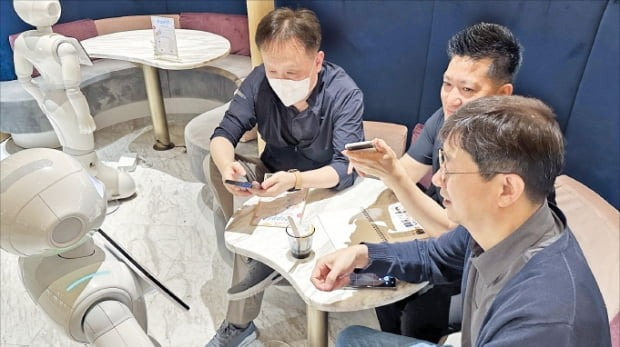 LG　Uplus　employees　communicate　with　robots　at　Pepper　Parlor,　a　robot　café　in　Tokyo　(Courtesy　of　LG　Uplus)