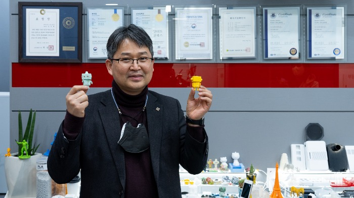 Kang　Jin-hwan,　the　founder　and　CEO　of　QNES　Global,　shows　products　made　with　a　QNES　micro　injection　molding　machine.　(Courtesy　of　A.TEAM　Ventures)