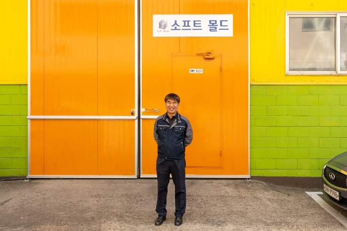 Soft　Mold　CEO　Kim　Jae-sim　poses　for　a　photo　in　front　of　Soft　Mold　factory　(Courtesy　of　CAPA)